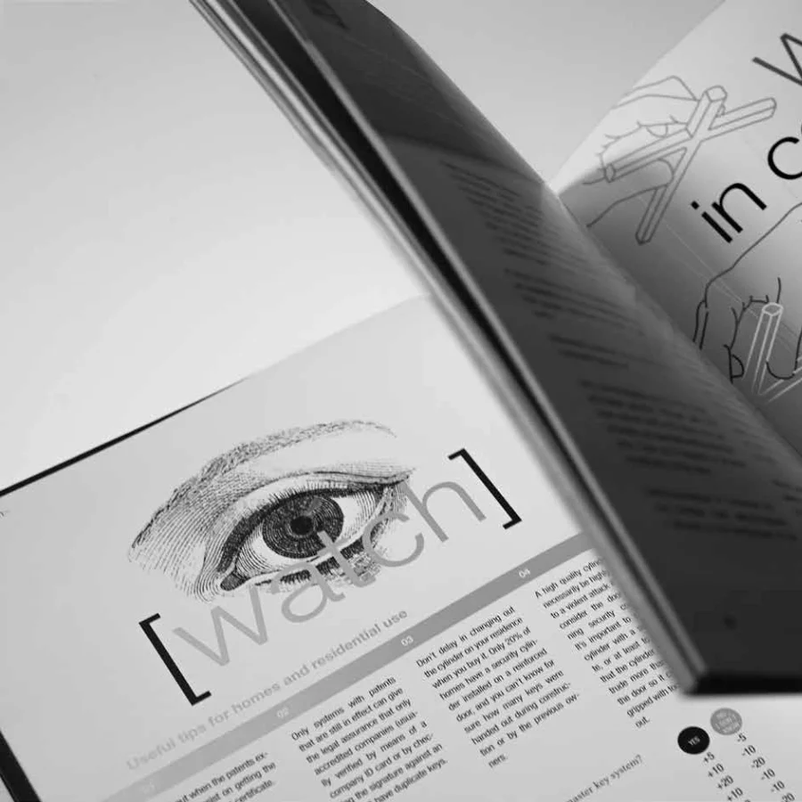 Libro de seguridad abierto mostrando la ilustración de un ojo con el texto 'Watch' sobreimpreso.